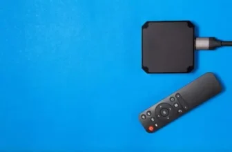 Um controle remoto ao lado de uma tv box.