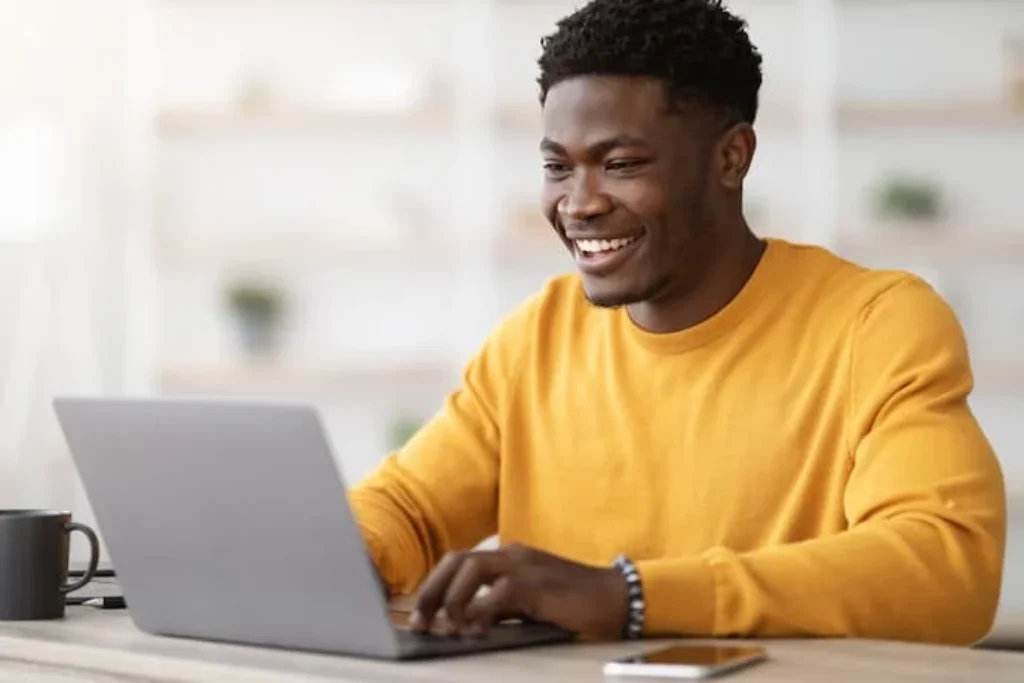 Um homem mexendo no notebook.