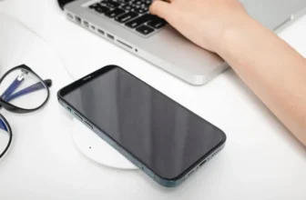 Um celular ao lado de um notebook.