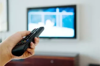 Um pessoa com um controle remoto na mão.